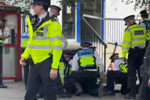 Officers detaining the youth on Fulham Broadway